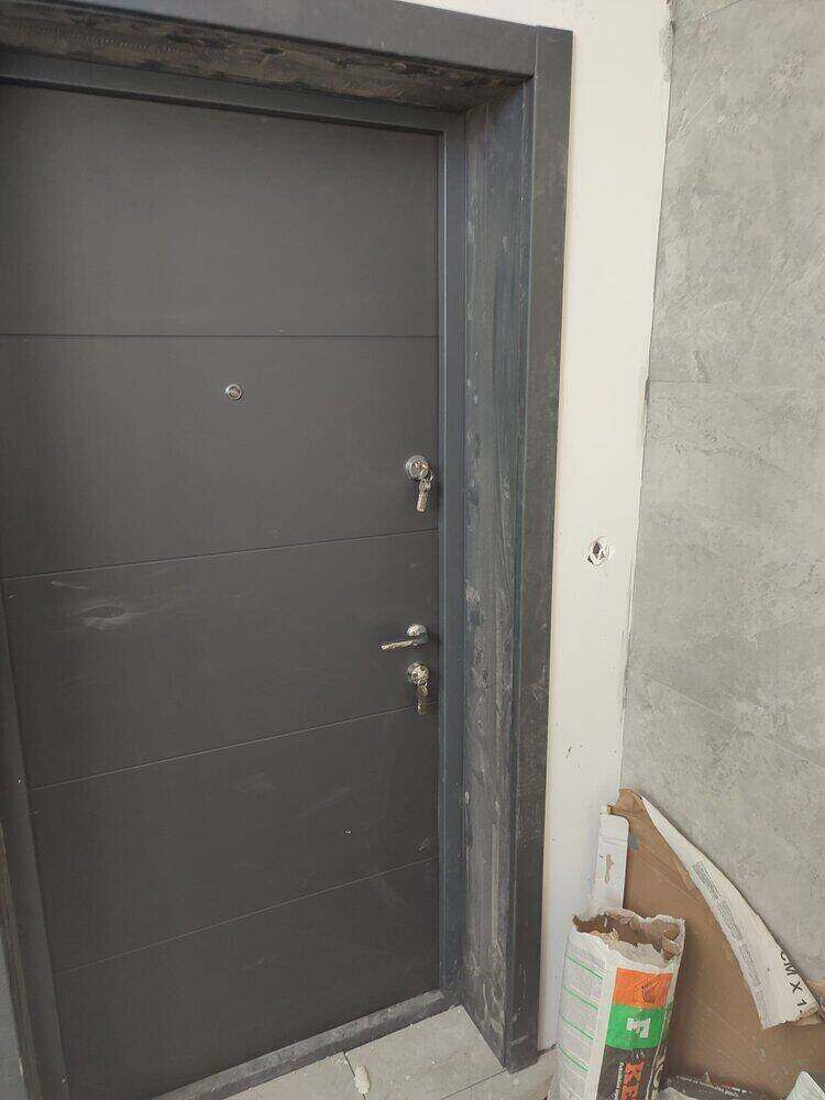 Siva ulazna vrata sa ključem u bravi